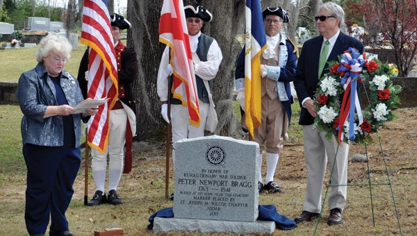 A marker in honor of American Revolutionary War soldier Peter Newport Bragg (1763-1841) was dedicated at the New Bethel Cemetery in Braggs on Sunday. At left is Jean Till Styles, regent of the Lt. Joseph M. Wilcox state chapter of the National Society Daughters of the American Revolution (NSDAR) and president of the Lowndes County Historical & Genealogical Society. At right is one of Bragg's descendents, Harry Houghton Smith of Montgomery. At back are members of the General Richard Montgomery Chapter, Sons of the American Revolution (SAR) Color Guard from Montgomery. 