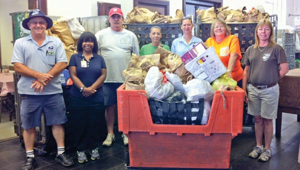 Postal employees pose with the more than one ton of food donated by local residents.  Left to right: Kip Smith, Celeste Kemp, Doug Brown, Missy Mitchell, Karla Bowlan, Bobbette Bowlan and Drenda Norris.
