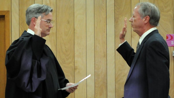 District Court Judge MacDonald Russell administers the oath of office to Georgiana Municipal Court Judge Wayne Bush Tuesday night at the Georgiana City Council meeting. (Advocate Staff/Andy Brown)