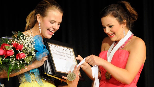 2011 Butler County Distinguished Young Woman Barrett Leverette, right, presents 2012 winner Anne Matthews, left, with her medal. The deadline For young women that reside in Butler County and will be high school seniors in the fall to register for the Butler County competition is June 28. (File Photo)