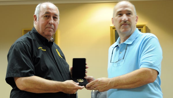 Greenville Police Chief Lonzo Ingram, left, presents Paul Stafford, right, with a badge in recognition of his father's service as police chief. (Advocate Staff/Andy Brown)