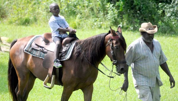 Paxton Moorer is led on a horse ride Thursday morning at Dunbar Summer Day Camp at Dunbar Community Center. The horse rides were part of the camp’s Wild, Wild West Week. (Advocate Staff/Jonathan Bryant)