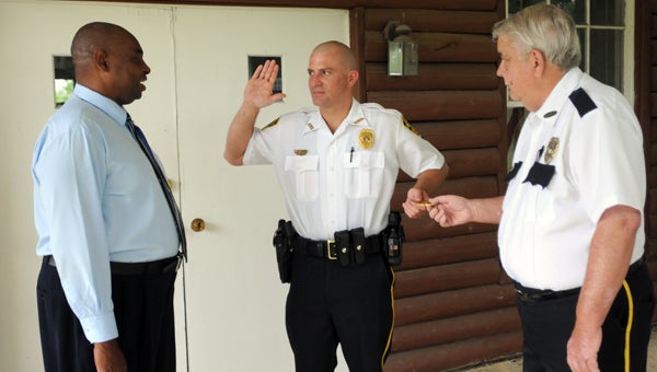 Georgiana Mayor Jerome Antone, left, swears in new police chief Isaac Ward, center, as former chief James Blackmon presents Ward with a chief’s badge. (Advocate Staff/Andy Brown)