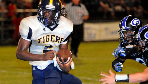 McKenzie School junior quarterback Terrance Clemons looks for running room during the Tigers’ 26-20 win over in-county rival Georgiana School Friday night at Harmon Field. (Advocate Staff/Jonathan Bryant)