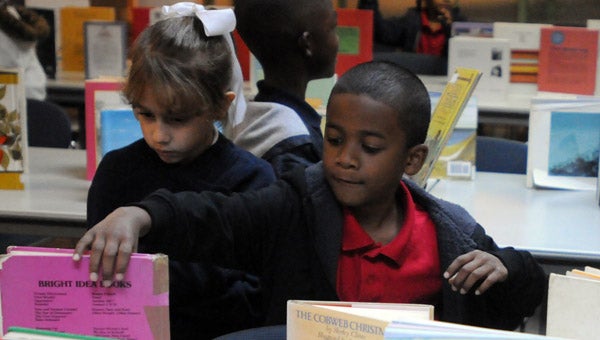 W.O. Parmer Elementary School first graders Lauren Houston, left, and Derrick Lawson, right, select a book Monday during a book giveaway by the Greenville-Butler County Public Library.  (Advocate Staff/Andy Brown)