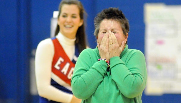 Fort Dale Academy cheerleader sponsor Marianne Russell reacts to seeing former cheerleaders stream onto the court during halftime of Friday's game with Springwood School. (Advocate Staff/Andy Brown)