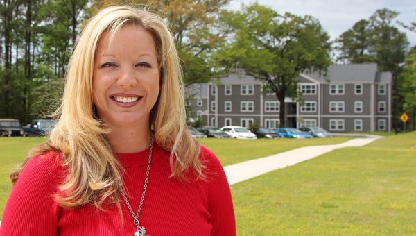 Jennifer Carroll Curry is LBW Community College’s 2014 Outstanding Alumna. Saints Hall student apartments in the background is a project she helped bring to reality when she served as president of the LBWCC Foundation. (Courtesy Photo)