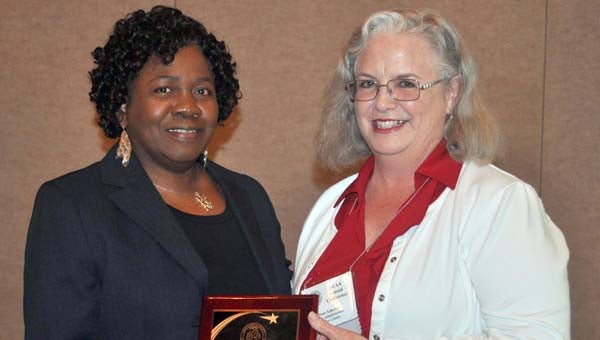 County Administrator Jacquelyn Thomas of Lowndes County (left) accepts the Association of County Administrators of Alabama’s award for 2014 County Administrator of the Year from her colleague Diane Kilpatrick of Butler County. (Courtesy Photo)