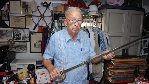 Georgiana’s Rob Williams shows off one the swords in his collection. Williams has been collecting military memorabilia for as long as he can remember. (Advocate Staff/Morgan Burkett)