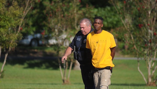 Sgt. Danny Bond leads Jimmy Little into the Greenville Police Department Wednesday afternoon. Little is a person of interest in a shooting that took place on South Street. (Advocate Staff/Andy Brown)