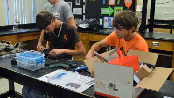 CONTRIBUTED PHOTO | KATIE SILVA  Tristan McCloud (left) and Austin Senn build robots for upcoming competitions.