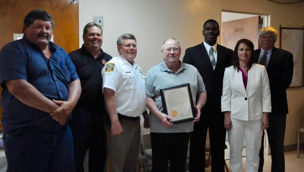 The Crenshaw County Commission met with retired chief deputy Jimmy Lecroy to present him with a dedicatory plaque. Pictured are, from left to right, Chris West,  Merrill Sport, Sheriff Mickey Powell, Jimmy Lecroy, Charlie Sankey, Michelle Stephens and Ricky McElwain. (Photo by Beth Hyatt)