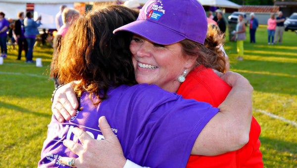 Rebecca Butts, co-chair of Relay, gives a warm hug to cancer survivor Shirley KIllough. Nineteen teams combined to raise $61,000 for the Butler County Chapter of the American Cancer Society. The months-long effort culminated Friday night with Relay for Life. (Advocate Staff/Angie Long)