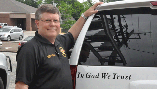 Sheriff Mickey Powell proudly ads his “In God We Trust” decal to his patrol vehicle. (Photo by Beth Hyatt)