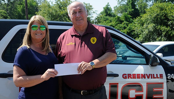 The Greenville Advocate donated $470 to the Greenville Police Department on Monday. The funds were raised through a child safety coloring book that was published by the newspaper and featured sketches of local law enforcement officers. Pictured are Greenville Advocate marketing coordinator April Gregory and Greenville Police Chief Lonzo Ingram. (Advocate Staff/Tracy Salter)