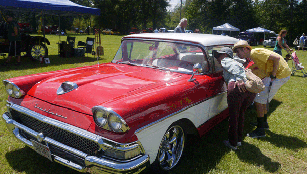 Car show attendees check out the interior of this red and white 1958 Ford Fairlane, owned by Tim Fuentes of Montgomery. The sedan was the top choice of of one of the event sponsors,  State Farm Agent Abby Gardner Ballew.