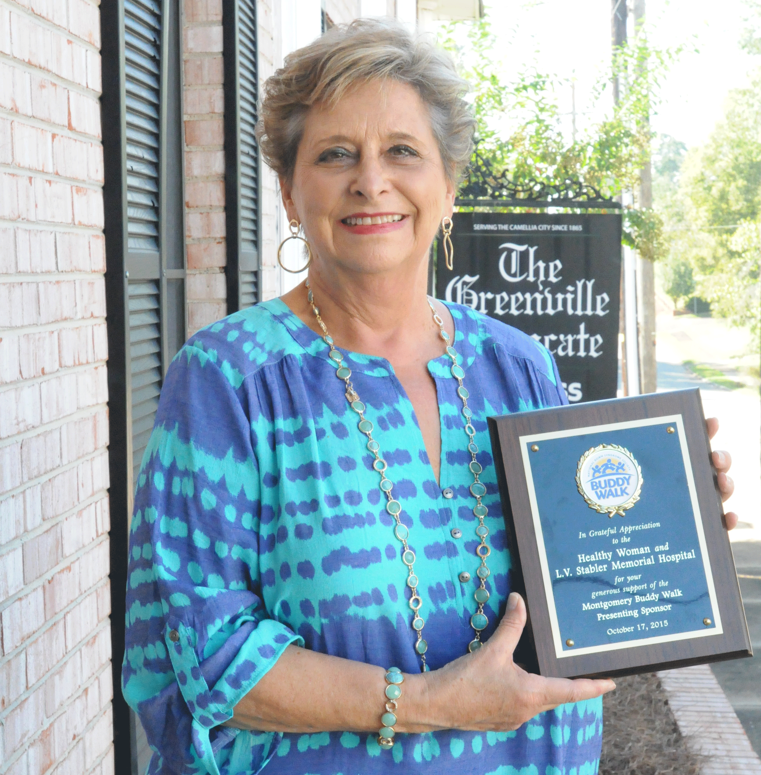 Linda Hummel, coordinator for the L..V. Stabler Memorial Hospital Healthy Woman program, displays a plaque signifying the hospital’s sponsorship of Buddy Walk.