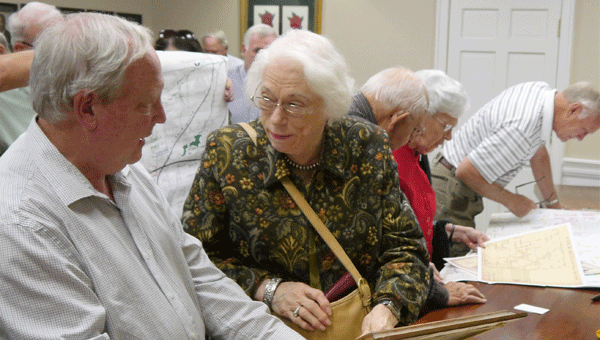 Historical society member Ann Feathers confers with map expert Craig Remington about a map brought from home following Remington's presentation Sunday. The director of the UA Cartographic Research Lab brought copies of a number of maps of local interest to donate to the research room.