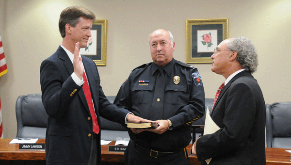 Outgoing Greenville Police Department chief Longzo Ingram (center) aids incoming chief Justin Lovvorn (left) in the swearing-in  ceremony.  Also pictured is Butler County Probate Judge Steve  Norman.