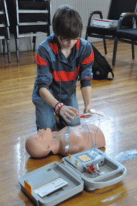 Luverne High School student Elijah Brooks practices his skills with the Automated External Defibrillator (AED). 