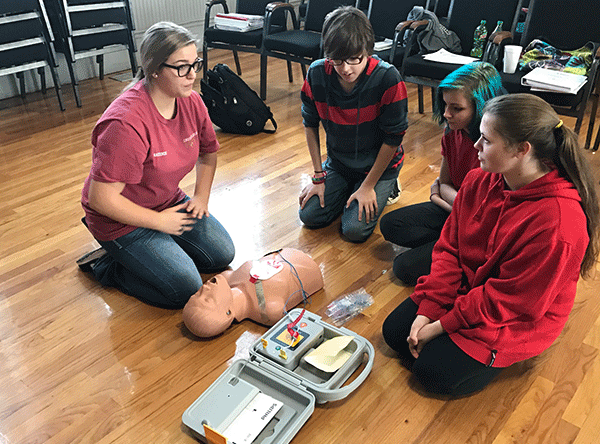 Luverne High School junior and Health Occupations Students of America (HOSA) member Mackenzie Carlos (left) instructs her fellow students in the proper way to attach and use an Automated External Defibrillator (AED). 