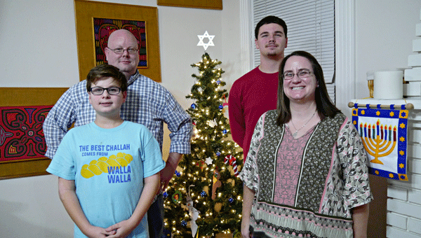 The Pryor family (clockwise from front) Jacob, Chris, Laun and Naomi, pose beside their festive Hanukkah bush. The family begins the observance of Hanukkah on Christmas Eve this year.