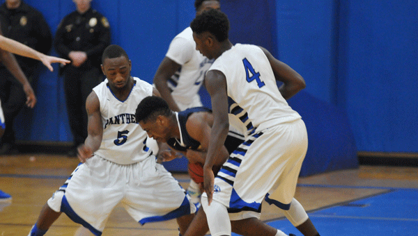 Georgiana guards Derrick Johnson (left) and Keinderus Mobley (right) smother McKenzie point guard Chris Shufford during the Panthers’ runaway 73-34 win over the neighboring Tigers.